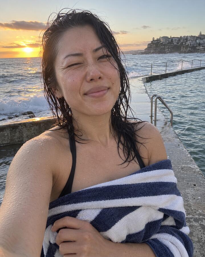 A woman wrapped in a towel after a sunrise ocean swim in Sydney